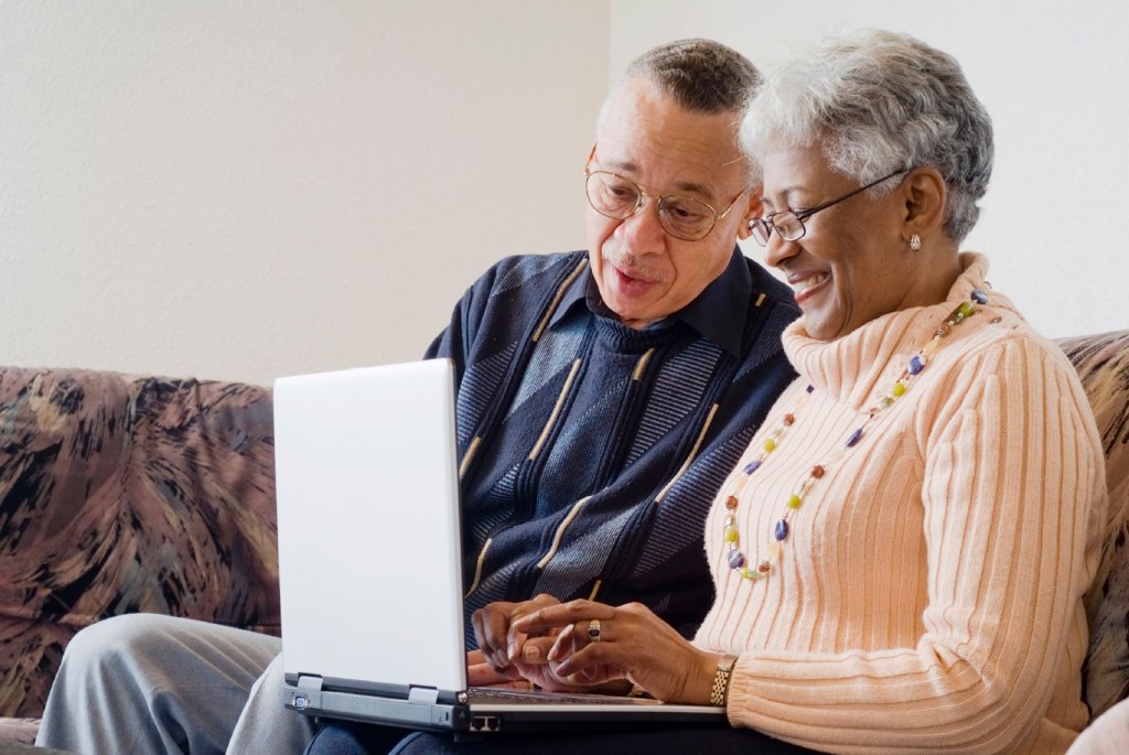 Couple learning to use a laptop at home
